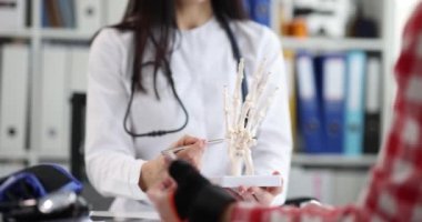 Klinikteki travmatologun resepsiyonunda elleri burkulmuş bir hasta. Sağlık sigortası veya uzuv yaralanması kavramı