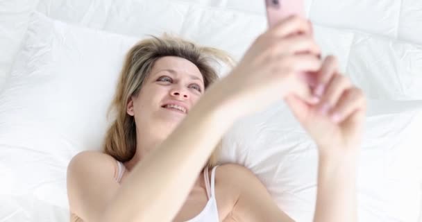 Mujer Joven Atractiva Sonriendo Mirando Cámara Del Teléfono Inteligente Mientras — Vídeos de Stock