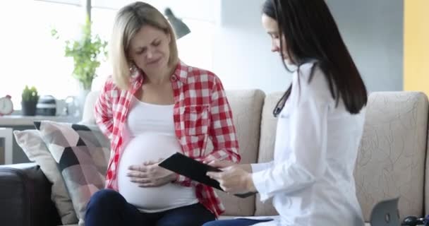 患有背痛和重症的孕妇与妇科医生沟通 有关怀孕最后一个月的医生咨询 — 图库视频影像