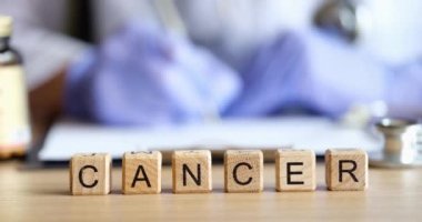 Doctor fills out medical paperwork and word cancer closeup. Diagnosis treatment drugs cancer concept