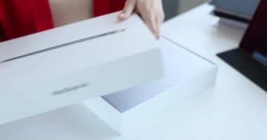 Minsk, Belarus, 12 Ekim 2021: Kadın yeni bir Apple Macbook Air ile beyaz kutuyu açıyor. Apple Macbook Hava Dizüstü Bilgisayarı açılıyor