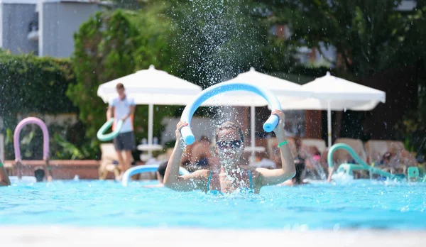 Junge Frau Klopft Nudel Auf Wasser Des Schwimmbades Auf Aqua Stockfoto