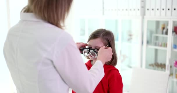 视力诊所有视力测试框架的儿童 眼科医生帮助选择治疗视力的眼镜 — 图库视频影像