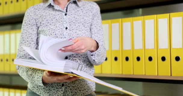 女会计经理在一个黄色文件夹里翻阅文件 业务文件和档案 — 图库视频影像