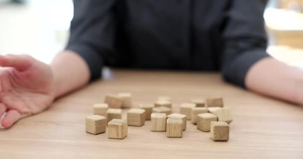 女性の手はテーブルの上に木製のキューブを投げる パズルの論理的思考 — ストック動画