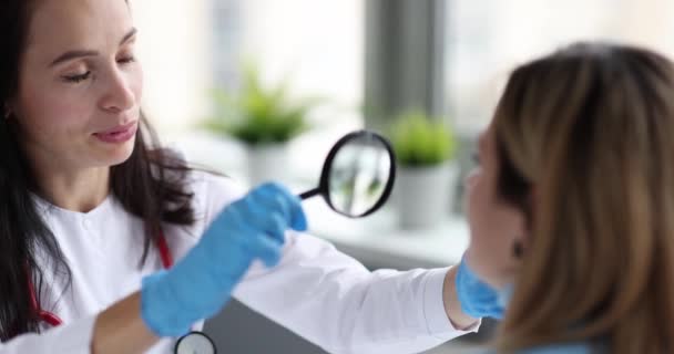 Doctor Cosmetoloog Onderzoekt Huid Van Geduldig Gezicht Met Vergrootglas Film — Stockvideo