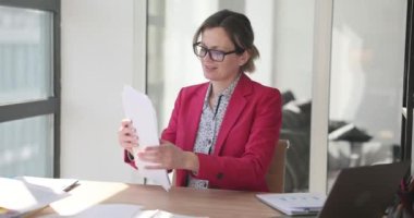 Kadın yönetici ofiste belgelerle çalışıyor. Belgelendirme ve mali raporlama ile çalış