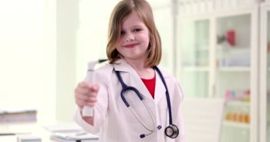 Elinde otoskop tutan güzel, gülümseyen doktor kızın portresi. Çocuk doktor ve çocukluk hayali olmak istiyor.