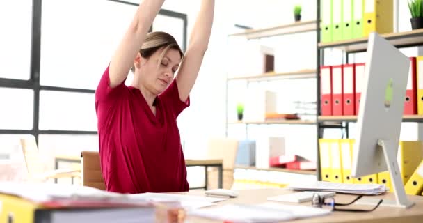 在办公室的工作场所 女人伸出手来 经理休息时坐在工作场所做一些简单的练习 — 图库视频影像