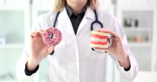 Tandarts Houdt Plastic Kaken Zoete Roze Donut Vast Begrip Tandheelkundige — Stockvideo