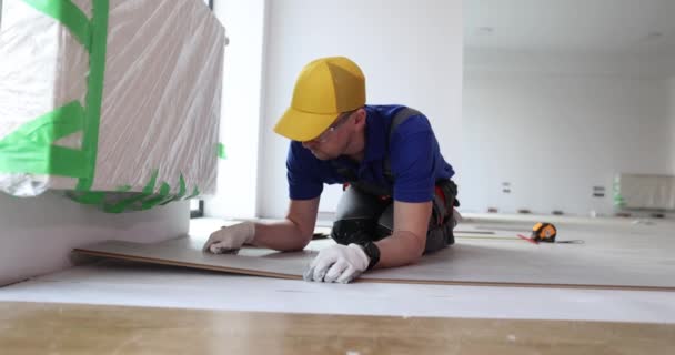 Male Repairman Laying Light Colored Laminate Natural Wood Fiber Installation — Stock Video