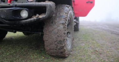Off-road 'a çıktıktan sonra kirli SUV' nin tekerine yaklaşıyoruz. Kırsal yolda çamurla kaplı bir SUV.