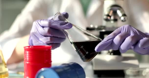 专家化学家在研究实验室里拿着一个装有油的瓶子 科学家对石油性质和质量的检验概念 — 图库视频影像