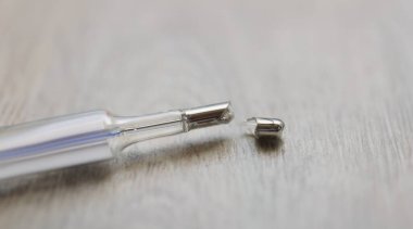 Kırık cıva termometresi gri arka planda, yakın plan. Vücut sıcaklığı için bozuk ölçüm aygıtı