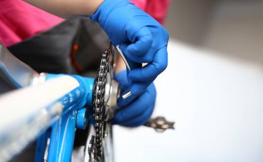 Bisiklet zincirini tamir eden askerlerin yakın görüntüsü. Ulaşım onarımı için özel aletin makro çekimi. Servis istasyonu ve araç atölyesi konsepti