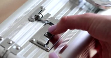 Kadın eli dijital kod açık metal bavul giriyor. Yanında da para var. 4K film yavaş çekim. Güvenli depolama kavramı