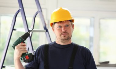 Aptal çalışan elektrikli matkap portre kullanarak. El ile iş DIY ilham geliştirme tamir dükkanı sarı kask sanayi başlangıç fikir endüstriyel eğitim meslek kariyer kavramı