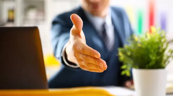 Man in suit and tie give hand as hello in office closeup. Friend welcome mediation offer positive introduction thanks gesture summit participate approval motivation male arm strike bargain