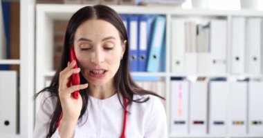 Kadın doktor hastasına akıllı telefondan danışıyor. Uzaktan tıbbi yardım kavramı