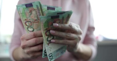 Kadın Belarus banknotlarını yüz ruble olarak görüyor. Belarus ekonomisi ve kriz kavramı
