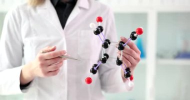 Laboratuvardaki kimyasal molekülü işaret eden kadın 4k 'lık yakın çekim filmi ağır çekimde. Genetik mühendisliği kavramı