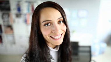 Kamerada poz veren neşeli bir kadının yakın çekimi. Güzel görünümlü esmer bir kadının Macro pozu. Sağ tarafta uzayı kopyala. Mankenlik ve güzellik konsepti