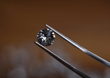 Küçük, değerli güzelliğin yakın plan görüntüsü. Kristal parlak değerli taşın makro çekimi. Lüks ve pahalı mücevherler. Renksiz mücevher. Muayenede kusursuz yuvarlak şekilli elmas