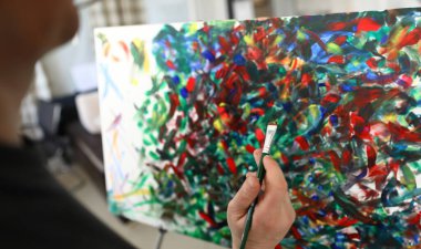 Yağlı fırça darbeleriyle resmin yakın görüntüsü. Yetenekli adam evde bir başyapıt yaratıyor. Çadır bezi ve boya fırçası. Sanat eserinin bir parçası. Modern sanat ve hobi konsepti