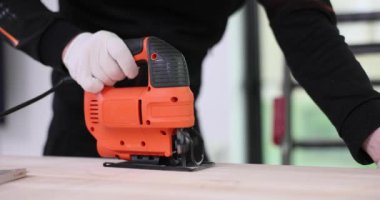 Usta tamirci elektrikli testereyle tahta testereyi kesiyor. 4K film yavaş çekim. Mobilya üretim konsepti
