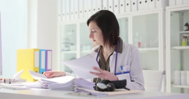 患者の検査用紙を調べる女性医師は 4K映画のスローモーションを文書化しています 医学コンセプトにおける論文 — ストック動画
