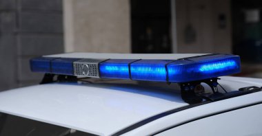 Şehirdeki polis arabasının çatısında mavi ışıklar. Polisi olay yeri konseptine çağır.