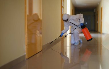 Tehlikeli madde uzmanları hastane ya da kamu binası koridorlarında temizlenir. Coronavirus dezenfeksiyon konsepti ve kapı tedavisi