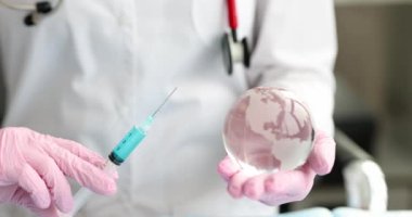 Eldivenli doktor şırıngayı aşı ve cam küreyle tutuyor. Dünya aşılama kavramı
