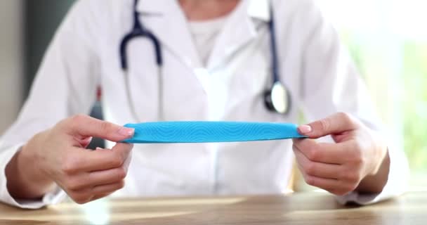 Vrouwelijke Therapeut Arts Toont Adverteert Blauwe Kinesiologie Fysio Tape Voor — Stockvideo