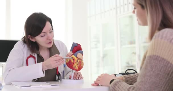 Lekarz Kardiolog Pokazuje Strukturę Ludzkiego Serca Pacjentowi Modelującemu Klinice Film — Wideo stockowe