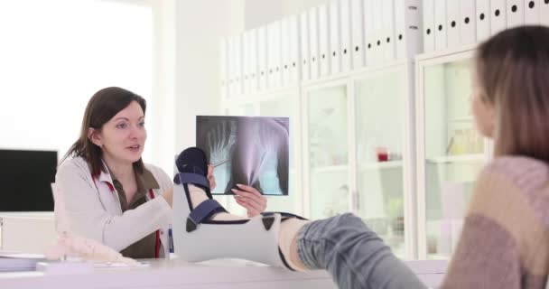 医生创伤学家展示了用绷带包扎的4K电影胶片慢动作对断腿患者进行的X线足骨检查 肢体骨折的治疗与诊断 — 图库视频影像