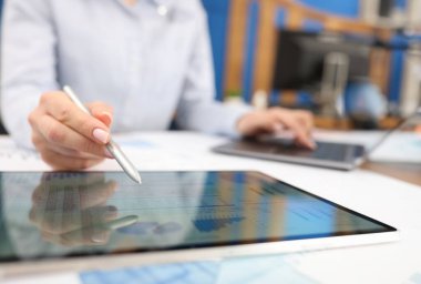 Stylus 'la birlikte dijital tablet üzerinde çalışan kadın el. Yönetim kavramı