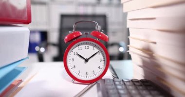 Red alarm clock for ten oclock on desktop with documents. Overtime and time management concept