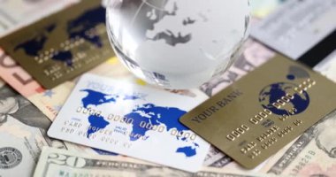 Glass globe bank notes and credit bank cards. World crisis and economy concept