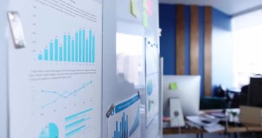 Manager attaches business statistics report to white board. Analytics and marketing concept