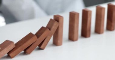 Risk and strategy in business is hand stopping the fall of wooden block. Prevention and development of fall in stability