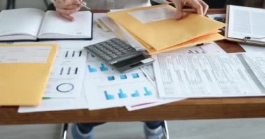 Woman secretary checks received correspondence at workplace. Business mail delivery concept