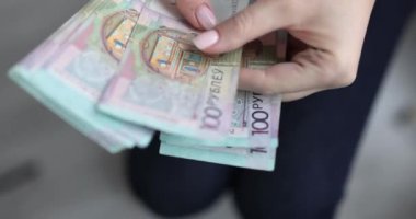 Woman counts Belarusian one hundred ruble banknotes. Belarusian economy concept