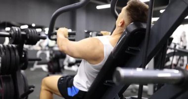 Erkek vücut geliştirici spor simülatörü 4k film yavaş çekim konsepti üzerinde kol kasları egzersizleri yapıyor.