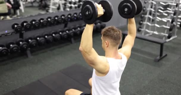 Άντρας Αθλητής Σηκώνει Αλτήρες Ενώ Κάθεται Γυμναστήριο Ταινία Αργή Κίνηση — Αρχείο Βίντεο