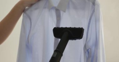 Ev hanımı gömleğini buharlı 4K filmli ağır çekimde ütülüyor. Kıyafet konsepti için çamaşır ve kuru temizleme hizmetleri
