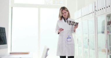 Hasta tıbbi belgelerine ve bilgisayar 4K filminde test sonuçlarına bakan kadın doktor. Doktor terapisti konsepti.
