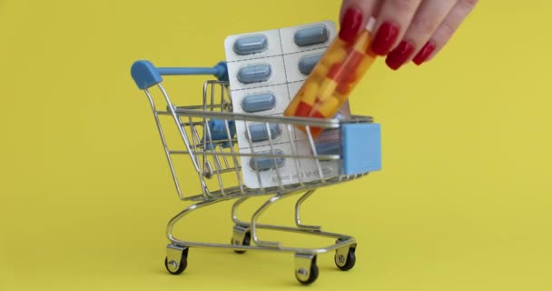 Comprador Colocando Frasco Drogas Carrinho Brinquedos Com Medicamentos Fundo Amarelo — Vídeo de Stock