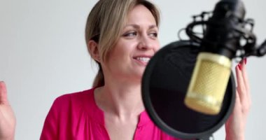 Stüdyo 4K filminde kadın radyo sunucusu mikrofona konuşuyor. Radyo konsepti üzerine çalış