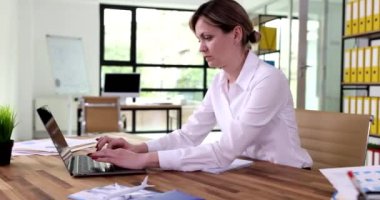 İş kadını, ofis 4K filminde dizüstü bilgisayarda klavye kullanıyor. Çevrimiçi iş kavramı